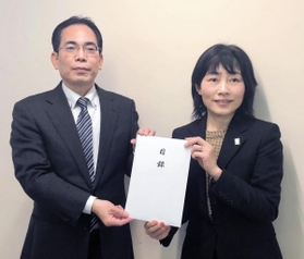 県女性青少年局の大久保和代局長（右）が沖縄県大阪事務所の糸数勝範所長に目録を贈呈した