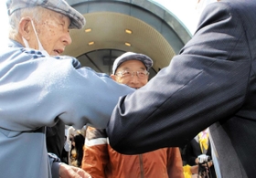 握手の代わりに「肘タッチ」で支持を呼び掛ける候補者＝２９日午前、高砂市内