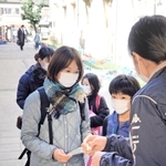 体温などを記入した登校予定表を提出する保護者や児童ら＝３日午前８時２０分、尼崎市三反田町２、市立立花南小学校