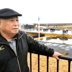 津波にさらわれた店の跡地周辺に立つ尾形勝壽さん＝８日午後、宮城県石巻市門脇町５