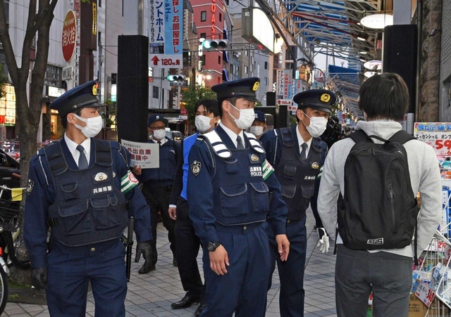 出歩く人に、不要不急の外出自粛を呼び掛ける警察官ら＝１７日午後６時１７分、神戸市中央区北長狭通１（撮影・後藤亮平）
