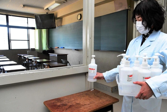 学校の再開後に教室に配る消毒液を確認する教員。再開に向けて感染予防対策が進む＝２３日午後、神戸市長田区寺池町１、兵庫高校（撮影・後藤亮平）