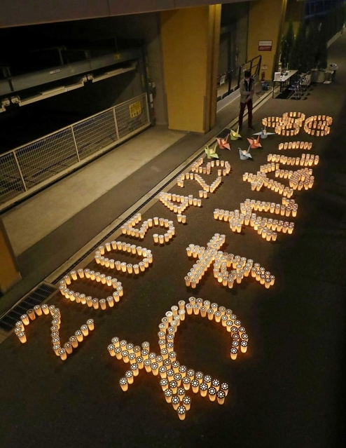 ろうそくの明かりで浮かび上がった「２００５・４・２５　わすれない」の文字＝２４日夜、尼崎市久々知３（代表撮影）