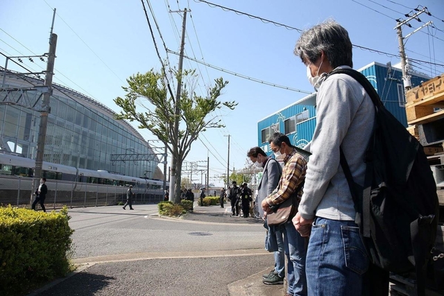 事故現場に向かって沿道で黙とうする人たち＝２５日午前９時１８分、尼崎市久々知３（撮影・風斗雅博）