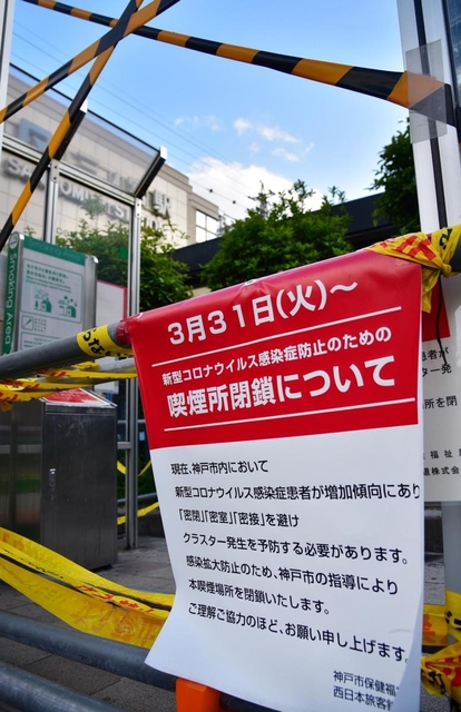 ３月末から閉鎖された駅前の喫煙所。お知らせが掲示され、進入禁止のテープが張り巡らされた＝２２日、神戸市中央区、ＪＲ三ノ宮駅前