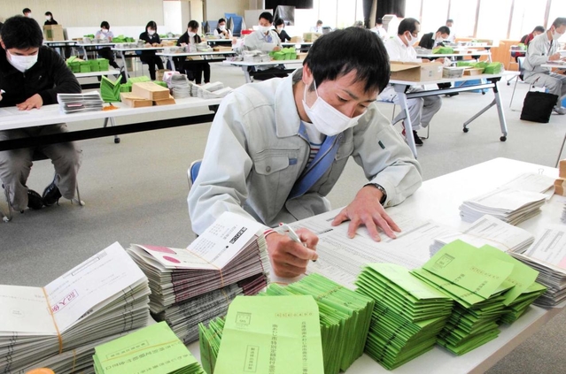 感染対策をしながら、申請書などの封入作業を急ぐ市職員＝２９日午前、南あわじ市役所