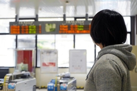 ＪＲの駅で改札を見つめるＡさん。事故の後遺症で、１０年近く電車に乗ることができなかった＝西宮市内