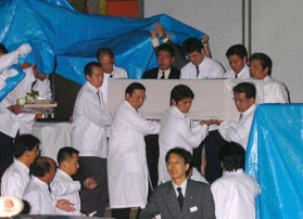 運び出される犠牲者の棺＝尼崎市記念公園総合体育館
