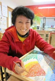 ちぎり絵に取り組む鈴木順子さん。「好きやからできる」＝西宮市内