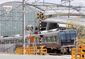 事故現場に整備された「祈りの杜（もり）」の横を走るＪＲの電車＝尼崎市内