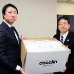 神戸市の山村昭こども家庭局長（右）にマスクを寄贈するキムラタンの清川浩志社長＝神戸市役所