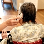 施設の携帯電話で家族と通話する入所者。面会できない寂しさを和らげる＝神戸市垂水区名谷町、特別養護老人ホーム「花の森」