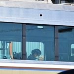 脱線事故から１５年の朝、現場を通過する電車内では手を合わせる乗客の姿があった＝２５日午前９時３０分、尼崎市久々知３（撮影・秋山亮太）