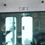 脱線事故から１５年の朝、現場を通過する電車内では手を合わせる乗客の姿があった＝２５日午前８時４８分、尼崎市久々知３（撮影・秋山亮太）