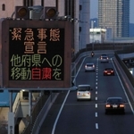 新型コロナウイルスの感染拡大防止のため、他府県への移動自粛を呼びかける電光掲示＝２５日午後、神戸市中央区東川崎町１（撮影・鈴木雅之）