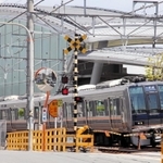 事故現場に整備された「祈りの杜（もり）」の横を走るＪＲの電車＝尼崎市内