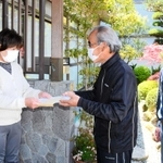 １０万円入りの封筒を各世帯に配る神種自治会の役員ら＝２９日午後、姫路市夢前町神種