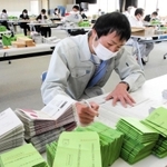 感染対策をしながら、申請書などの封入作業を急ぐ市職員＝２９日午前、南あわじ市役所