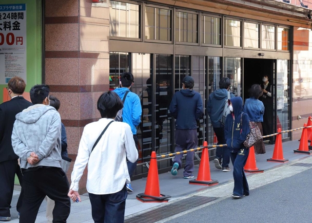 開店を待っていた客が一定の間隔を空けながら次々と入っていくパチンコ店＝１日午前、神戸市灘区（撮影・吉田敦史）