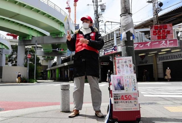常連客から差し入れされたというマスクを着けて街頭に立つ男性＝神戸市中央区旭通５