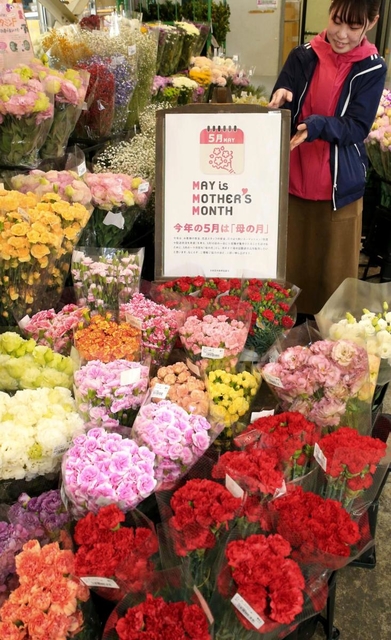 「母の月」をＰＲするポスターが掲げられた生花仲卸店。色とりどりのカーネーションが並ぶ＝姫路市御国野町、姫路生花卸売市場