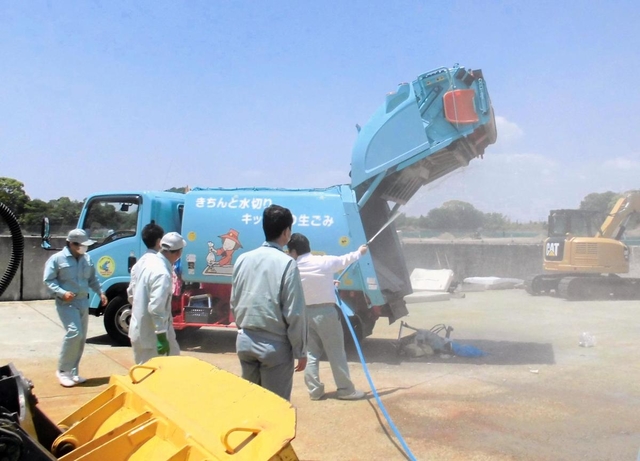 ごみ収集車の消火にあたる作業員ら（明石市提供）