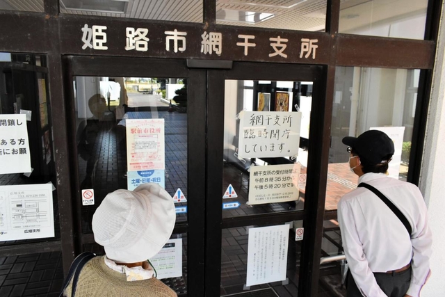 臨時閉庁の案内を確認する市民ら＝姫路市網干区垣内中町