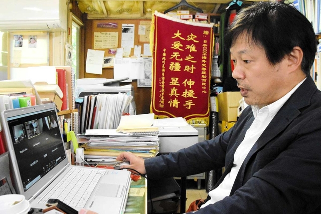海外のＮＧＯ関係者らとオンライン会議で情報交換する吉椿雅道さん＝神戸市兵庫区中道通２