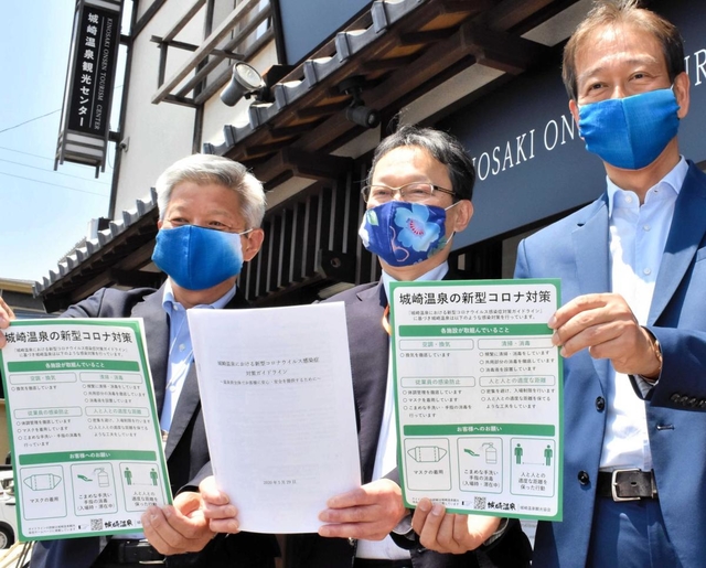 客への対応などをまとめたガイドラインを手にする城崎温泉観光協会の高宮浩之会長（右）ら＝豊岡市城崎町湯島