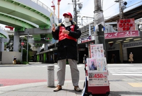 常連客から差し入れされたというマスクを着けて街頭に立つ男性＝神戸市中央区旭通５