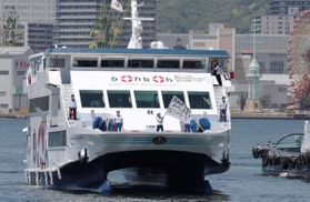 医療従事者を激励しようと、船上から旗を振る船員ら＝８日正午ごろ、神戸市中央区のポートアイランド沖（撮影・辰巳直之）