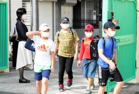 マスクを着け、約１カ月ぶりに登校する児童ら＝１８日午前、尼崎市下坂部１、尼崎市立下坂部小学校