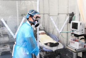 陰圧ブースに入れた患者を見守る看護師＝神戸市須磨区大池町５、高橋病院