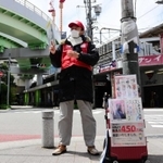 常連客から差し入れされたというマスクを着けて街頭に立つ男性＝神戸市中央区旭通５