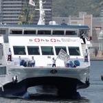 医療従事者を激励しようと、船上から旗を振る船員ら＝８日正午ごろ、神戸市中央区のポートアイランド沖（撮影・辰巳直之）
