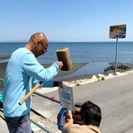 サーフィンの自粛を呼び掛ける張り紙を設置する徳島県サーフィン連盟のメンバー＝徳島県阿南市内（武知さん提供）