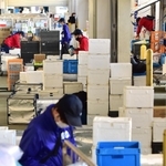 受注の急増を受け、出発直前まで積み込み作業に追われる配達員＝神戸市東灘区魚崎浜町、共同購入センター東灘