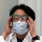 職員が使う眼鏡型のプラスチック防具を着ける栗本院長＝神戸市中央区港島南町２、神戸アイセンター病院