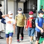 マスクを着け、約１カ月ぶりに登校する児童ら＝１８日午前、尼崎市下坂部１、尼崎市立下坂部小学校