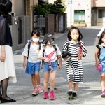 約１カ月ぶりに登校する児童ら＝１８日午前、尼崎市下坂部１、下坂部小学校