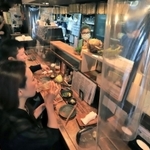 感染予防のためカウンター席にビニールシートを設置した店内で飲食を楽しむ常連客ら＝２３日夜、神戸市兵庫区羽坂通３（撮影・斎藤雅志）