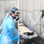 陰圧ブースに入れた患者を見守る看護師＝神戸市須磨区大池町５、高橋病院