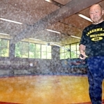 部活動再開に向けて練習場を消毒する、猪名川高レスリング部の浅井功監督＝兵庫県猪名川町紫合（撮影・秋山亮太）