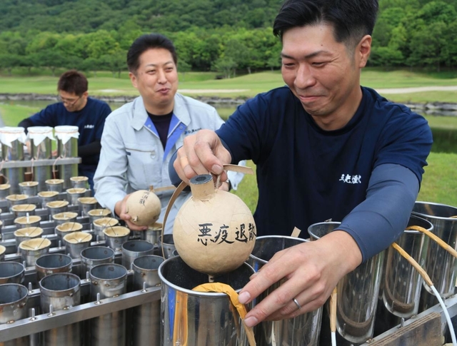 「悪疫退散」などの文字を書き込んだ花火玉を発射台に詰める花火師ら＝１日午後、たつの市神岡町田中、龍野クラシックゴルフ倶楽部（撮影・小林良多）