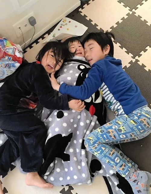 寝起きの煌之介ちゃん（１）＝中央＝を抱き締める信之亮君（６）と愛紗ちゃん（４）