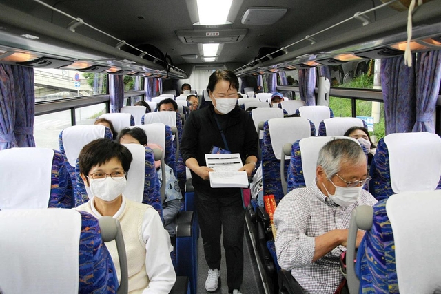 感染防止に努めたツアーバス内で表情を緩める参加者ら＝ＪＲ相生駅前