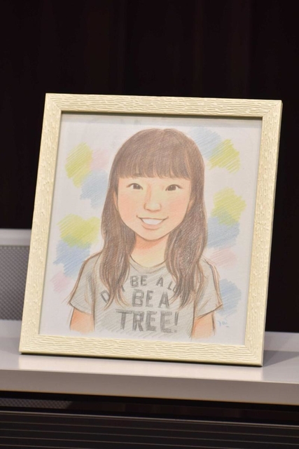 再調査委員会の報告を受けた遺族代理人の会見に置かれた女子生徒の似顔絵。１４歳の誕生日にケーキの火を吹き消す姿という
