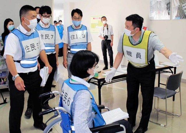 避難所の開設・運営訓練で住民を誘導する自治体の職員＝神戸市中央区山本通４