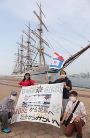 ベンガラ染めのメッセージを作成した桜井加津子さん（右上）。仲間らと練習帆船「日本丸」を見送った＝３日午前、神戸市中央区新港町（撮影・吉田敦史）