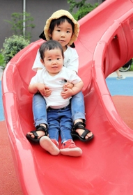 仲良く滑り台で遊ぶ芙來ちゃん（１）＝前＝と莉來ちゃん（５）